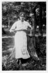 Vera Irene (Martin) Bosomworth posed in front of the stump of the first tree cut on the bank of the Grand River in Elora