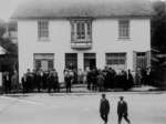 Crowd of people in front of a building on the southwest corner of Main and Geddes, in Elora.