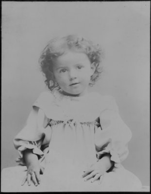 Portrait of a young child, with shoulder length curly hair.