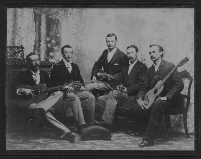 Group portrait of five men, including John Connon, holding musical instruments.