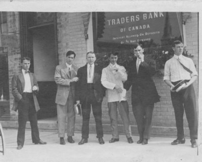 Group portrait of unidentified young men standing in front of the Elora branch of the Traders Bank of Canada.