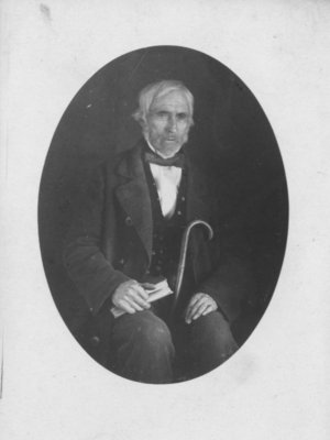 Portrait of an unidentified man, seated with book and cane.