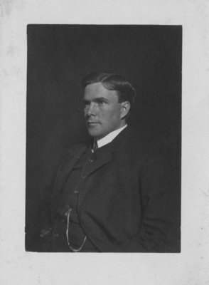 Portrait of an unidentified young man in a business suit, with a watch chain.