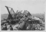 View of a freight train wreck with equipment in place to clear the wreckage.