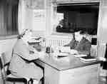 Unidentified Woman and Man Sitting at an Office Desk