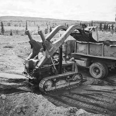 Crawler Tractor Loading Dirt into Dump Truck