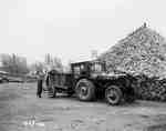 Tractor With a Homemade Cab Next to Lumber Pile