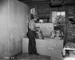 Unidentified Man Loading a Milk Can into a Cooler