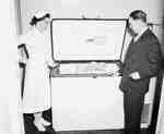 Unidentified Man and Female Nurse Look Inside a Freezer, Yorkton, SK