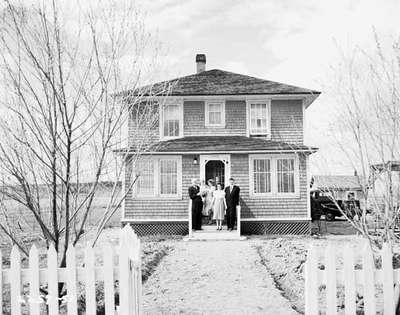 Unidentified Family Posing for Photo Outside House