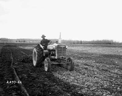 Unidentified Man Disking a Field