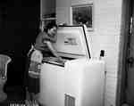 Unidentified Woman Looks into a Freezer