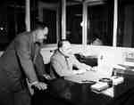 R.A. (Bob) Mitchell and J.H. Kain Reviewing Paperwork in an Office