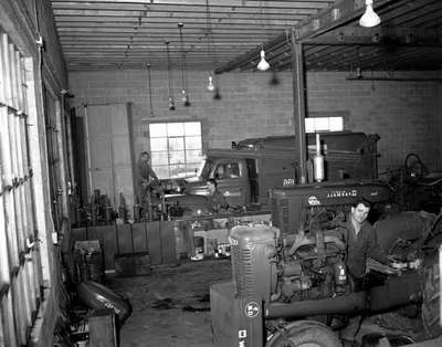 Men Servicing Vehicles in a Farm Equipment Dealership Workshop, Elmira, ON