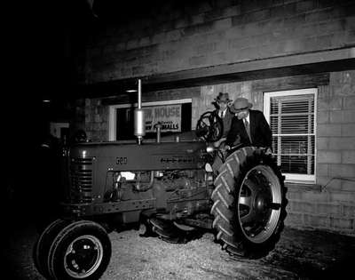 Two Unidentified Men Look at a Tractor at a Farm Equipment Dealership Open House, Milton, ON