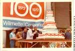 People on a stage with Centennial cake