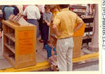 Child sitting on the curb between book shelves