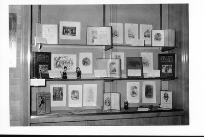 Library display of early editions of Charles Dickens with figurines of the characters