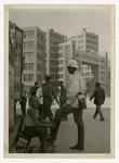 A traffic officer is getting a shoeshine from a young boy